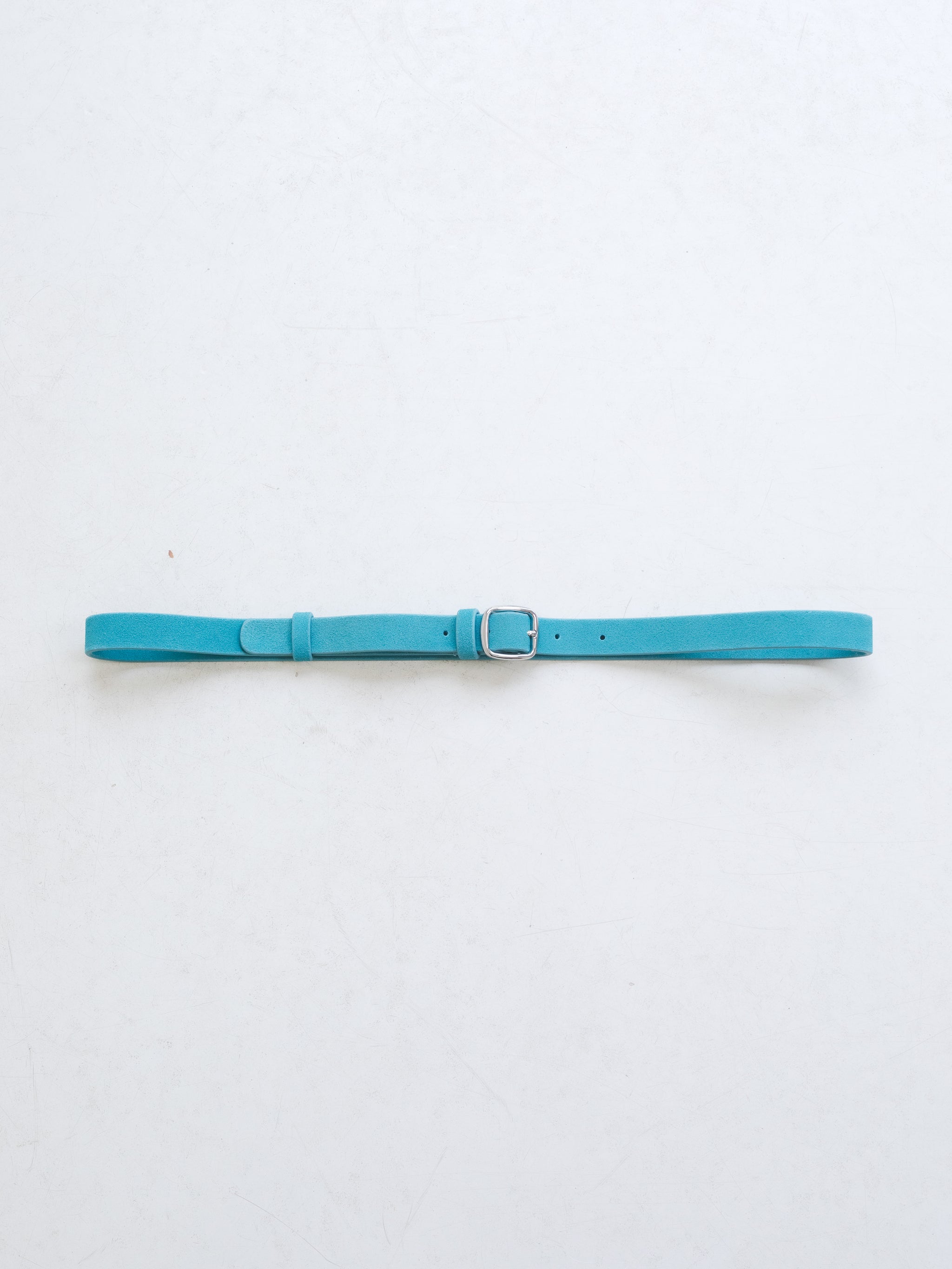 A bright blue leather belt with silver metal buckle on a white background. 