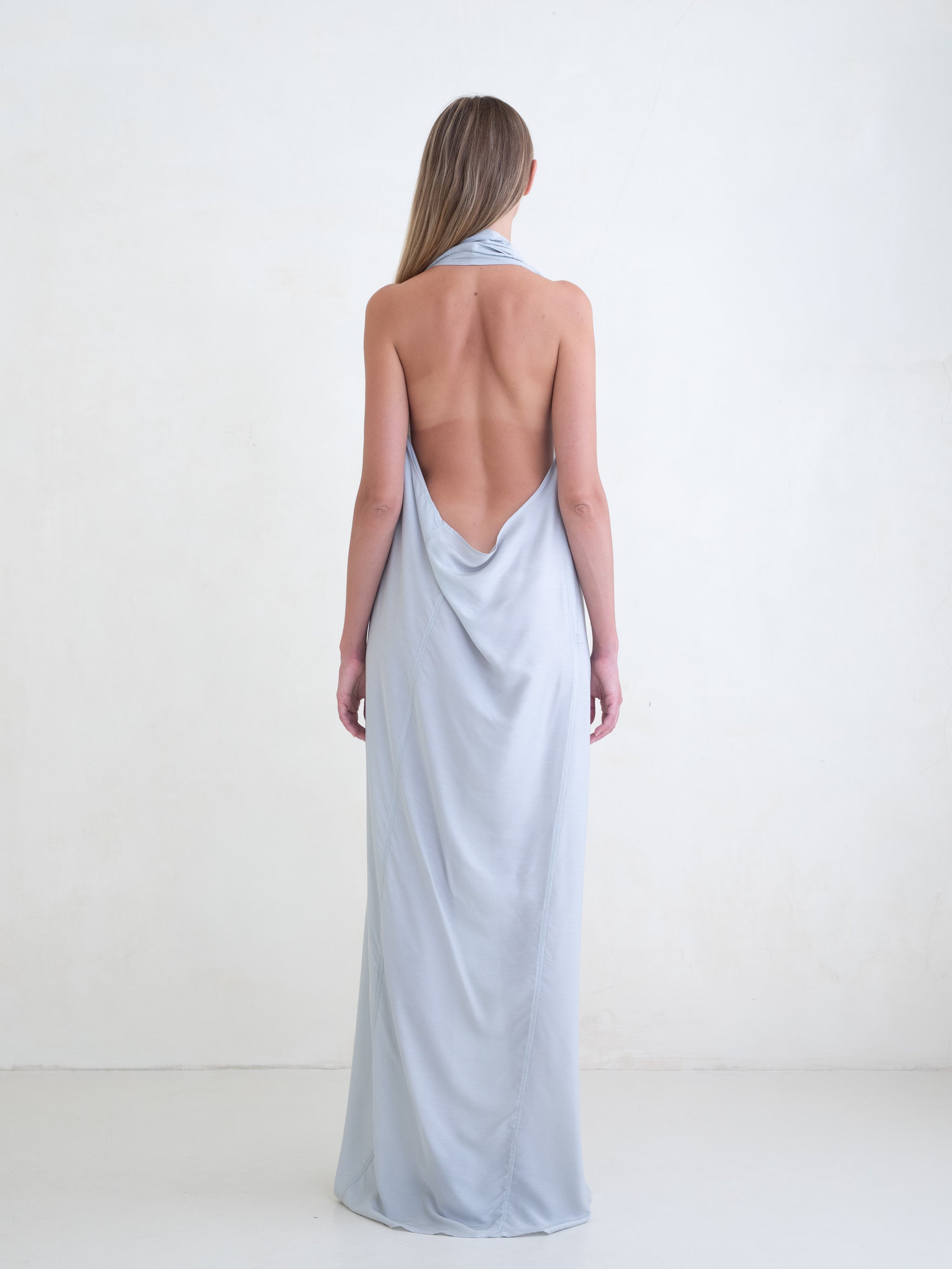 Woman wearing a light blue sleeveless maxi dress on a white background 