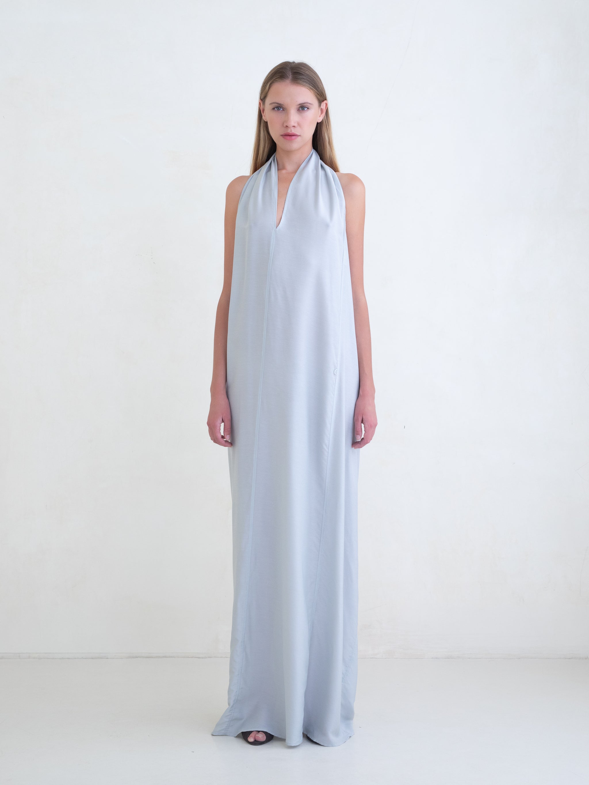 Woman wearing a light blue sleeveless maxi dress on a white background 