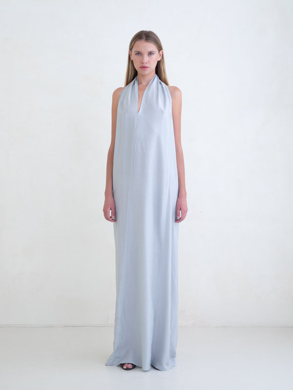 Woman wearing a light blue sleeveless maxi dress on a white background 