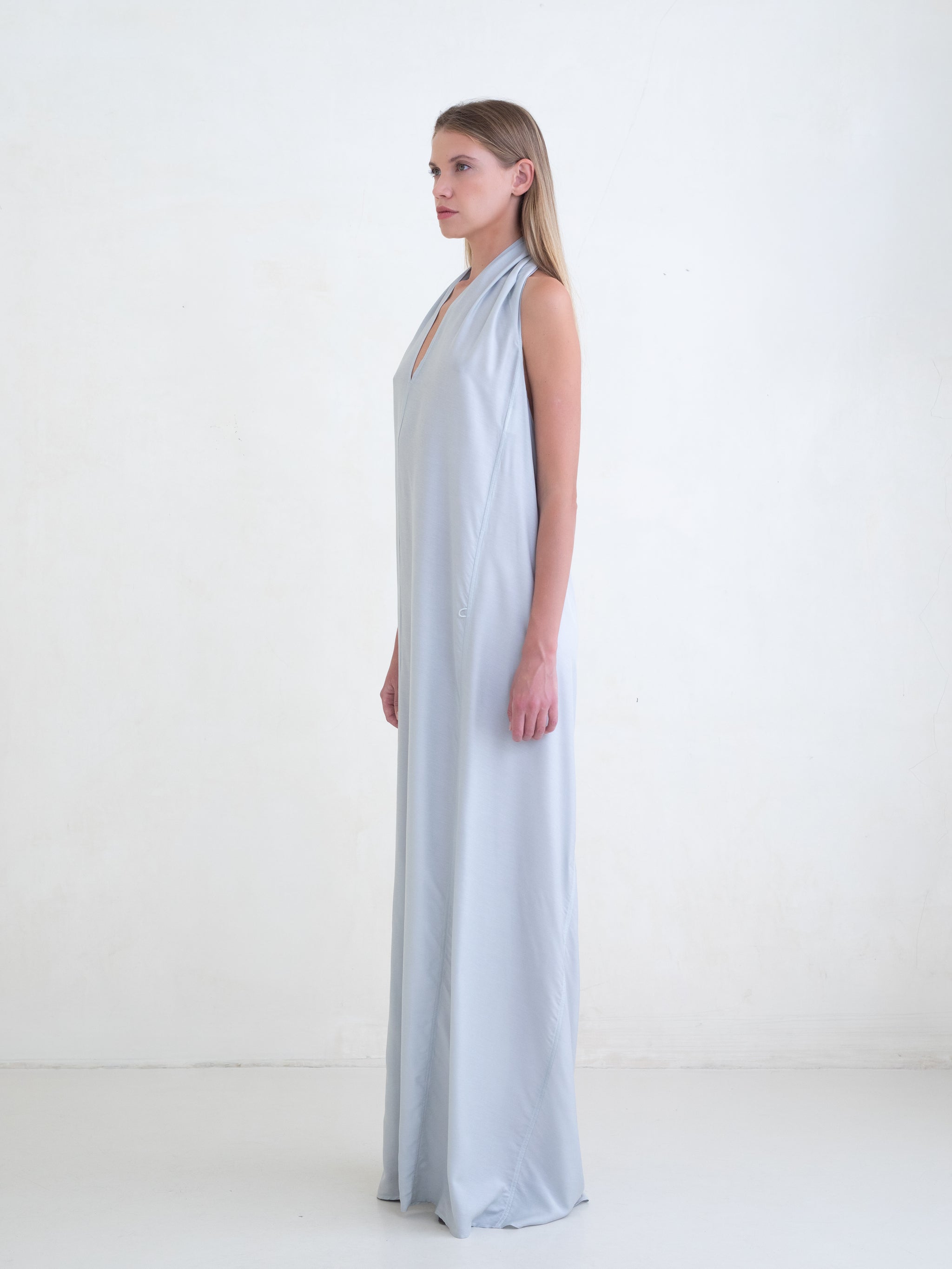 Woman wearing a light blue sleeveless maxi dress on a white background 