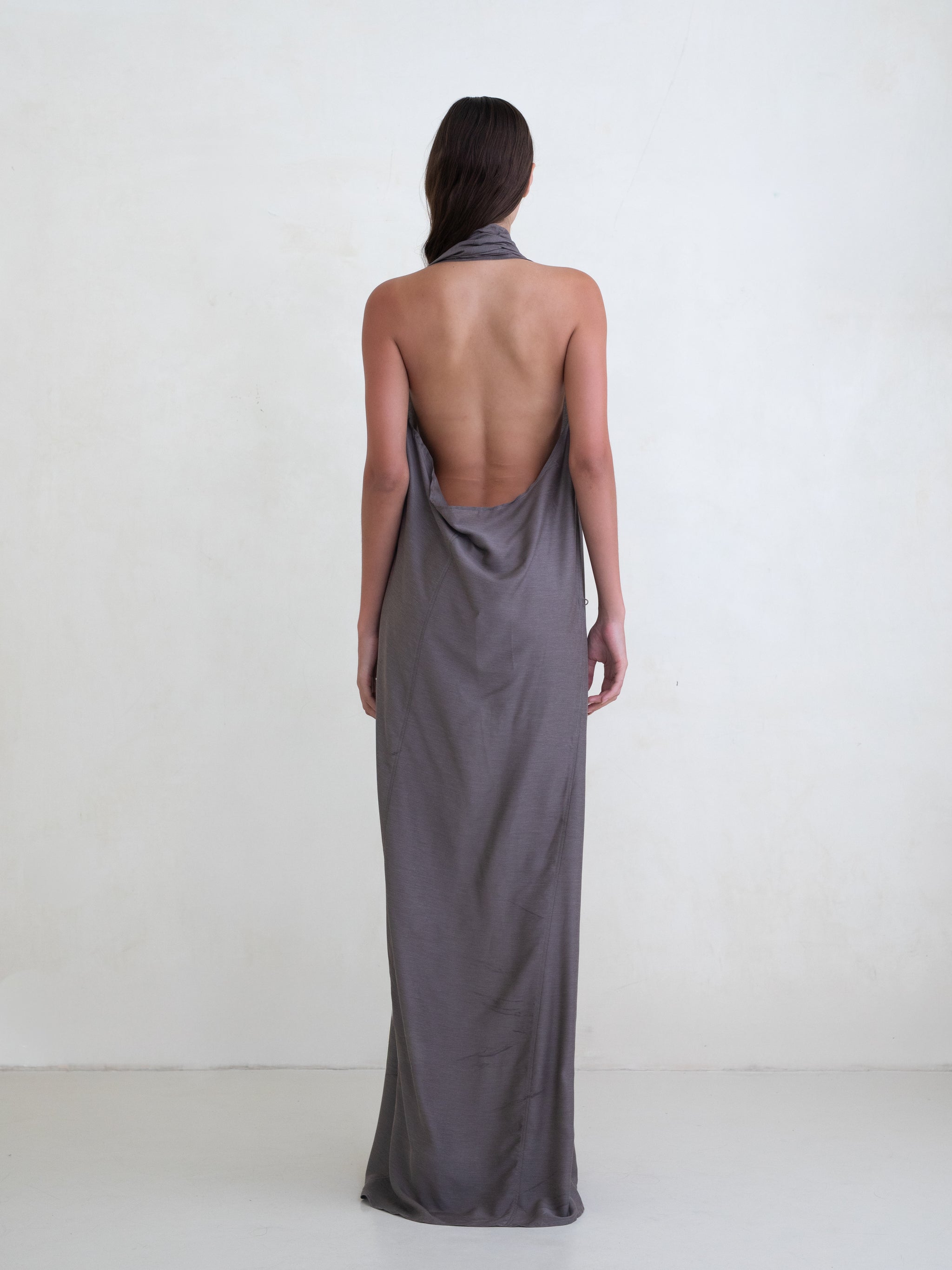 Woman wearing a taupe sleeveless maxi dress on a white background 