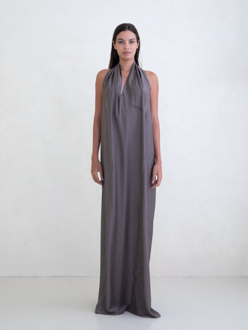 Woman wearing a taupe sleeveless maxi dress on a white background
